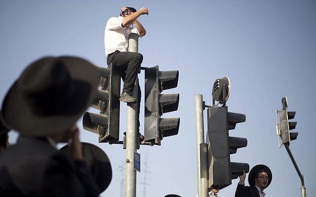 Ultra-Orthodox Jews block a main road during a demonstration in Jerusalem against the conscription of members of the ultra-Orthodox community to the IDF on October 19, 2017. (AP Photo/Ariel Schalit)
