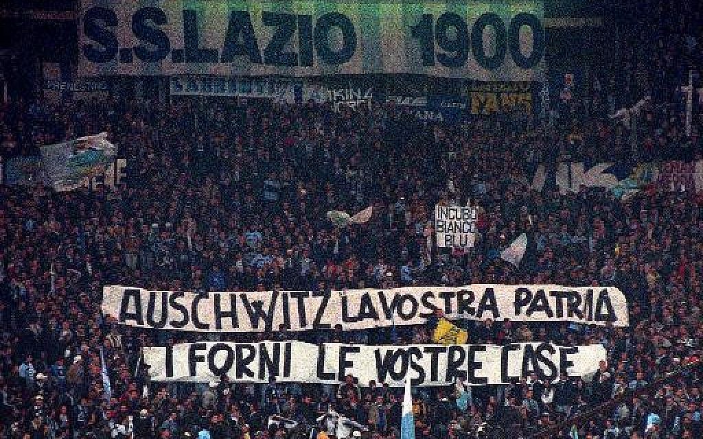 In this Nov. 29, 1998 file photo, Lazio fans display banners from the stands reading "Auschwitz is Your Homeland. The Ovens are Your Homes" during a Serie A match between Lazio and AS Roma, at Rome's Olympic stadium. Lazio fans have a long history of racism and anti-Semitism but the Roman club's supporters established a new low on Sunday, Oct. 22,  2017 when they littered the Stadio Olimpico with superimposed images of Anne Frank _ the young diarist who died in the Holocaust _ wearing a Roma jersey.  (AP Photo/Plinio Lepri,)