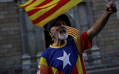 A Catalonia independence supporter wearing the Estelada flag stamped on his t-shirt chants against the Spanish State outside the Catalan government's Generalitat building in Barcelona, Spain, October 30, 2017. (AP/ Gonzalo Arroyo/ File)