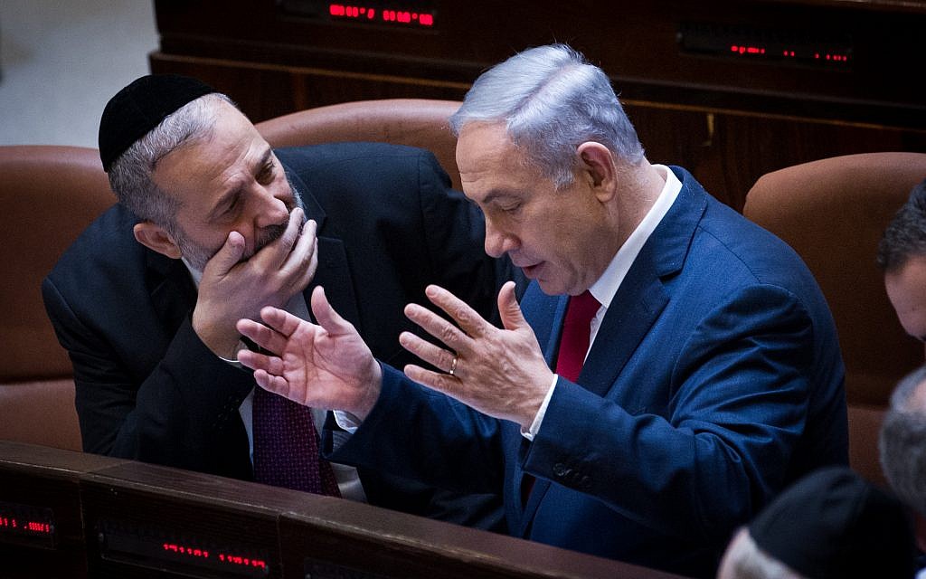 File: Prime Minister Benjamin Netanyahu, right, speaks with Interior Minister Aryeh Deri during a plenum session in the Knesset, January 11, 2016. (Miriam Alster/Flash90)