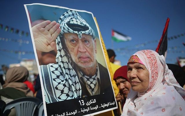 Palestinians hold pictures of late leader Yasser Arafat in Gaza City on November 9, 2017, during a festival to commemorate the 13th anniversary of his death. (AFP PHOTO / MOHAMMED ABED)