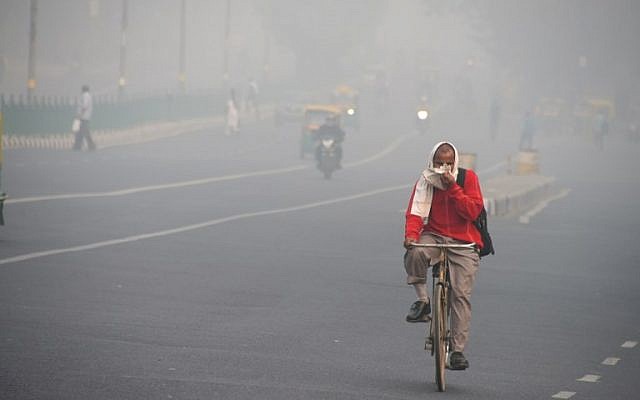 An Indian man rides a bike amid heavy smog on a street of New Delhi on November 10, 2017. (AFP/DOMINIQUE FAGET)
