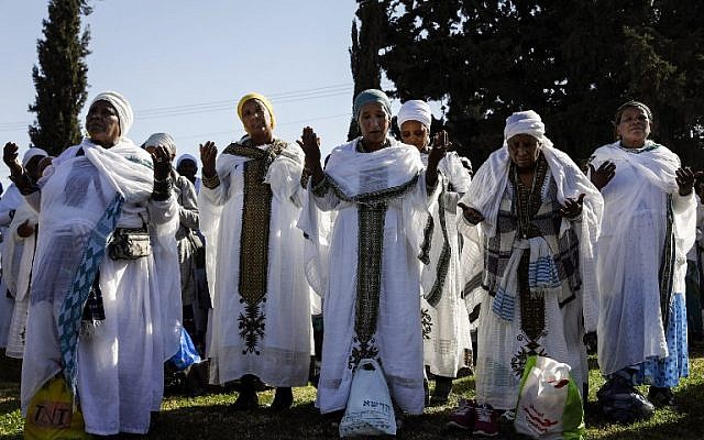 Israeli women from the Ethiopian Jewish community pray during the Sigd holiday marking the desire to 'return to Jerusalem', as they celebrate from a hilltop in the holy city overlooking the Temple Mount, on November 16, 2017. (AFP PHOTO / GALI TIBBON)