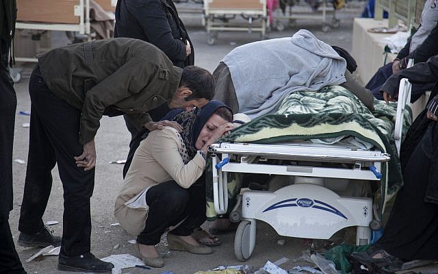 Os parentes lloram sobre o corpo de uma vítima do terremoto, em Sarpol-e-Zahab, no oeste do Irã, 13 de novembro de 2017. (Farzad Menati / Tasnim News Agency via AP)