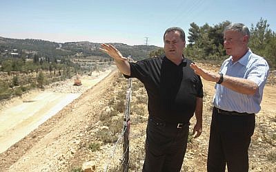 Israel's Transporation Minister Yisrael Katz, center, stands with Netivei Israel CEO Shai Baras, later arrested for cronyism, as they inspect the construction of a new highway between Jerusalem and Tel Aviv, on June 12, 2013. (Flash 90)