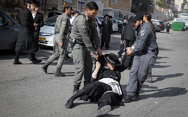 Ultra-Orthodox Jewish men clash with police during a protest against the arrest of a religious seminary student who failed to comply with a recruitment order, next to the army draft office in Jerusalem, November 28, 2017. (Flash90)