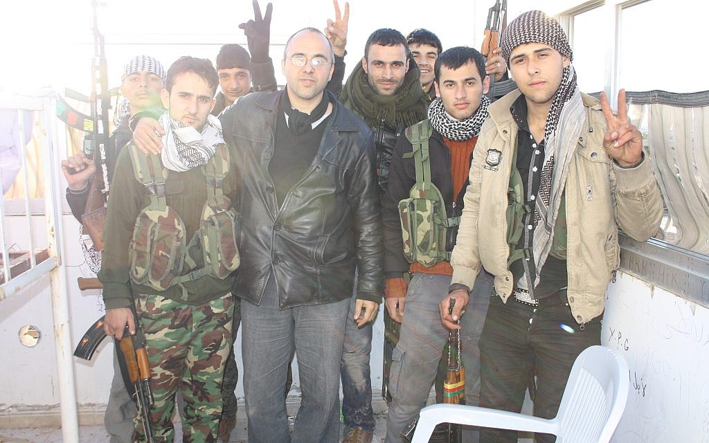 Jonathan Spyer, wearing a black leather jacket, meets with Kurdish YPG fighters in northern Syria in 2013. (Courtesy)