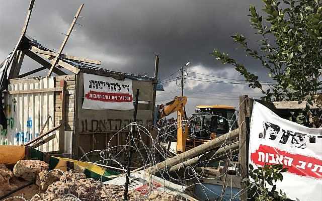 A bulldozer demolishes a woodshop at the illegal Netiv Ha'avot outpost, November 29, 2017 (Jacob Magid/Times of Israel)