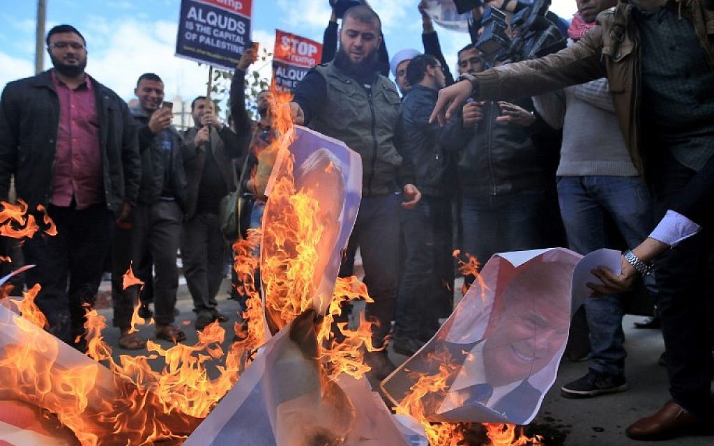 Palestinian protesters burn pictures of US President Donald Trump and Prime Minister Benjamin Netanyahu following Trump's decision to recognize Jerusalem as the capital of Israel, in Gaza City, on December 7, 2017.  (AFP PHOTO / MOHAMMED ABED)