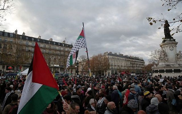 Demonstrators wave flags as they take part in a protest in Paris on December 9, 2017, against US President Donald Trump’s recognition of Jerusalem as Israel’s capital. (AFP photo/Zakaria Abdelkafi)