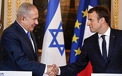 Prime Minister Benjamin Netanyahu (L) and French President Emmanuel Macron shake hands during a joint news conference following their meeting at the Elysee Palace in Paris on December 10, 2017. (AFP/Pool/Philippe Wojazer)