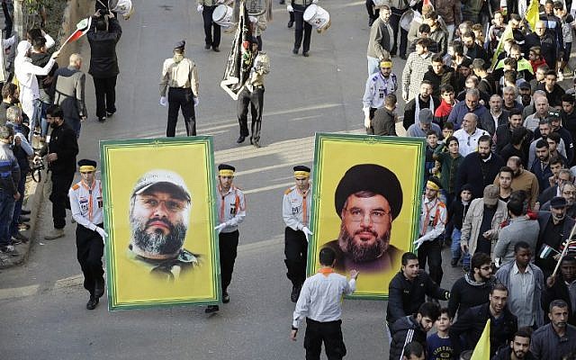 Supporters of Lebanon’s Hezbollah terror group hold portraits of its leader Hassan Nasrallah (R) and its former military chief Imad Mughniyeh during a protest in Beirut on December 11, 2017. (AFP Photo/Joseph Eid)