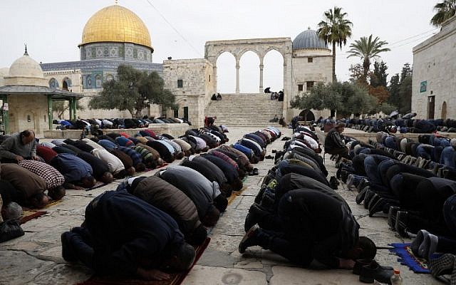 Illustrative: Muslim worshipers perform Friday noon prayer near the Dome of the Rock shrine in Jerusalem's Old City's al-Aqsa mosque compound on the Temple Mount, December 22, 2017. (AFP Photo/Ahmad Gharabli)