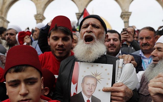 Muslim worshipers hold a portrait of Turkish President Recep Tayyip Erdogan following Friday noon prayer in Jerusalem's Old City's al-Aqsa mosque compound on the Temple Mount, December 22, 2017. (AFP Photo/Ahmad Gharabli)