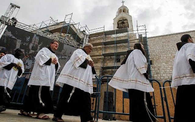 Roman Catholic deacons and clergymen walk in a procession prior to Christmas eve at the Manger Square outside the Church of the Nativity in the West Bank town of Bethlehem, December 24, 2017.  (Wisam Hashlamoun/Flash90)