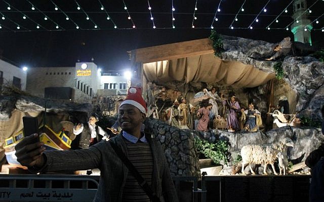 A man takes a selfie at the Manger Square outside the Church of the Nativity as people gather for Christmas Eve celebrations in the West Bank town of Bethlehem, December 24, 2017. (AFP Photo/Musa Al Shaer)