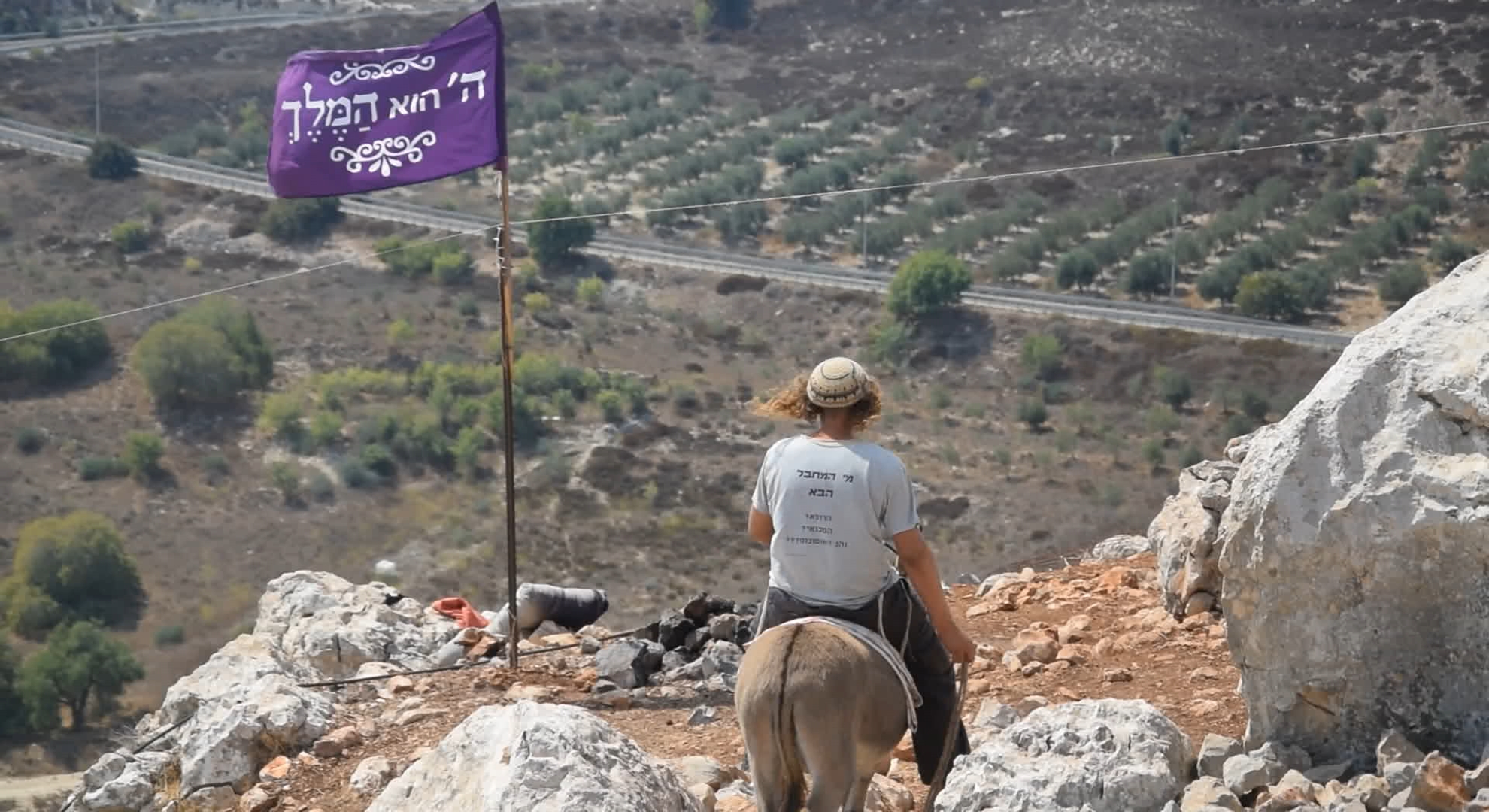 Illustrative: A member of the 'hilltop youth' rides a donkey at an illegal outpost in the northern West Bank. (Credit: Zman Emet, Kan 11)