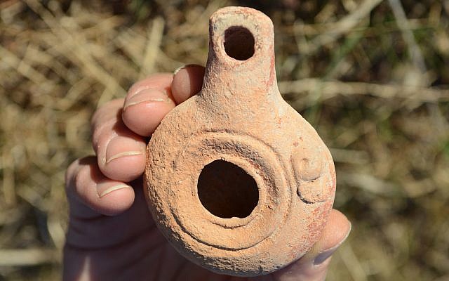An intact 2,200-year-old clay lamp found next to porcupines' cave in the Beit Shean Valley. (Miki Peleg, Israel Antiquities Authority)