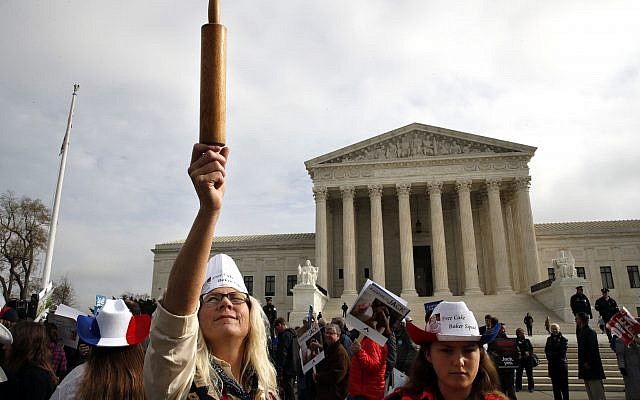 Mary Torres of Falls Church, Virginia, left, holds a rolling pin up in support of cake artist Jack Phillips, while outside of the Supreme Court with her daughter Maria Torres, right, Tuesday, December 5, 2017, during arguments on the 'Masterpiece Cakeshop v. Colorado Civil Rights Commission' case in Washington. (AP Photo/Jacquelyn Martin)