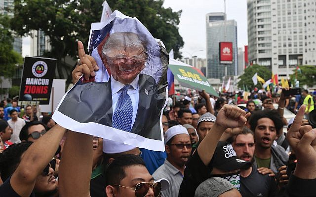 Muslims crumple a portrait of US President Donald Trump during a protest outside the US Embassy in Kuala Lumpur, Malaysia, December 8, 2017. (AP Photo/Sadiq Asyraf)