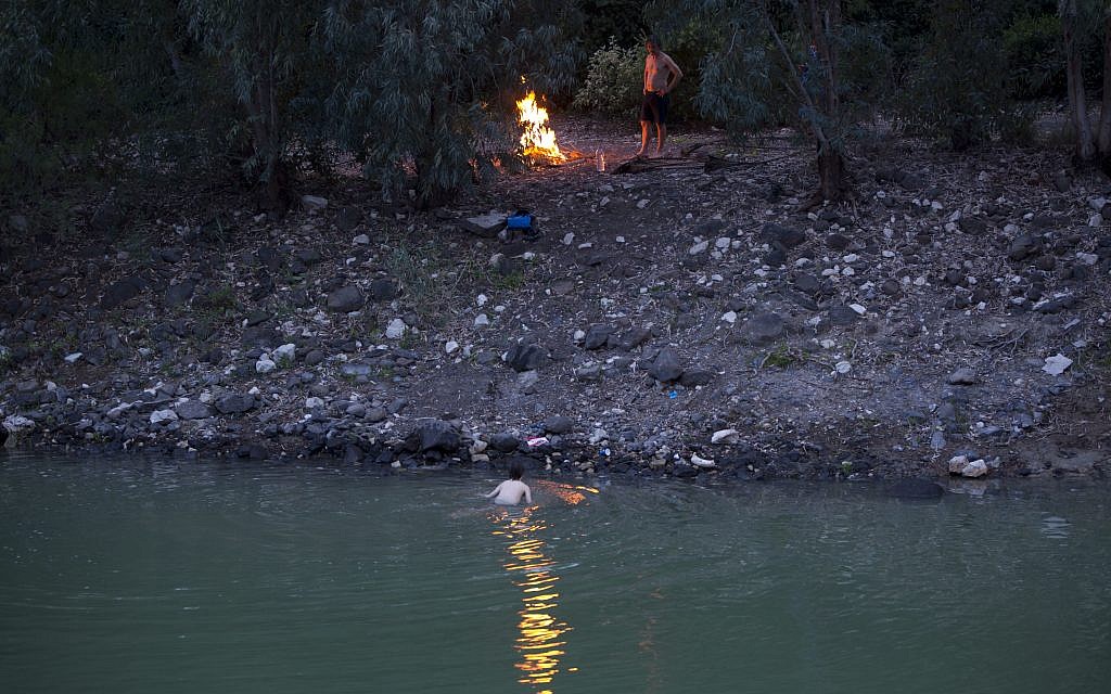 In this Tuesday, April 11, 2017 photo, Israelis camp out on the banks of the Jordan River near the northern Israeli Kibbutz of Kinneret. (AP Photo/Oded Balilty)