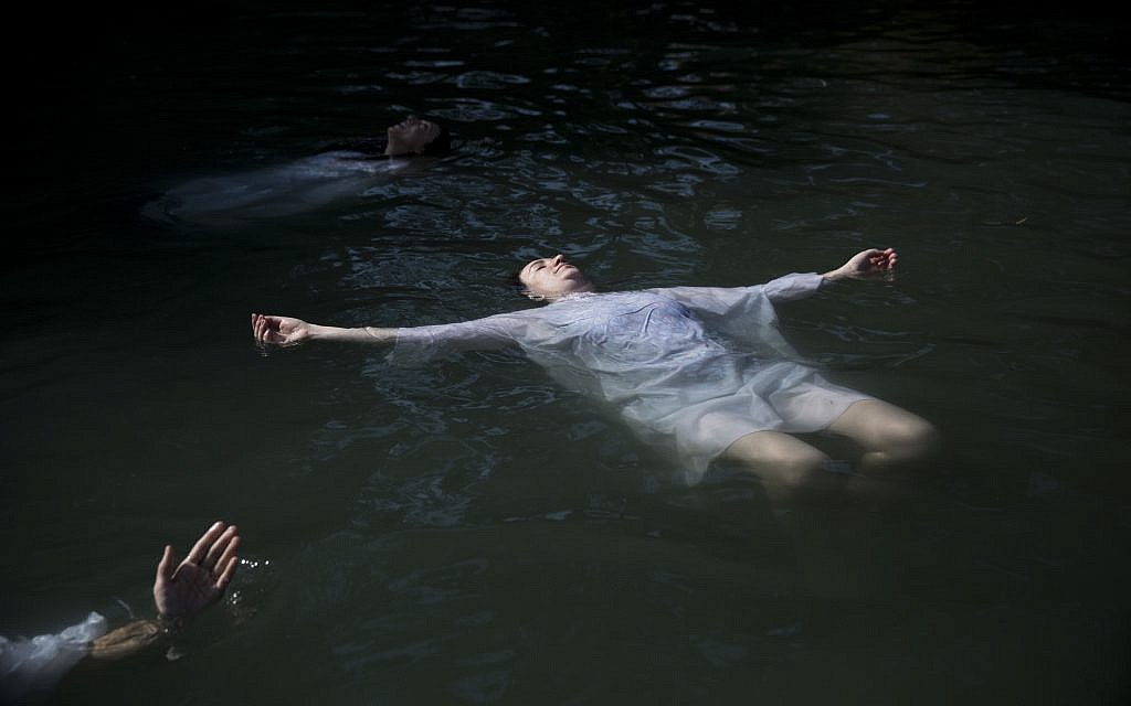In this Tuesday, June 20, 2017 photo, Christian pilgrims baptize in the Jordan River at Yardenit baptismal site in northern Israel. (AP Photo/Oded Balilty)