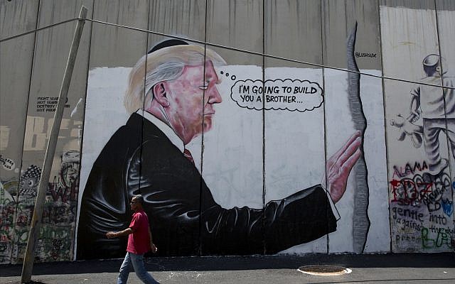 A mural resembling the work of elusive artist Banksy, depicting US President Donald Trump wearing a Jewish skullcap, adorns Israel's West Bank security barrier in Bethlehem, August 4, 2017. (Nasser Nasser/AP)