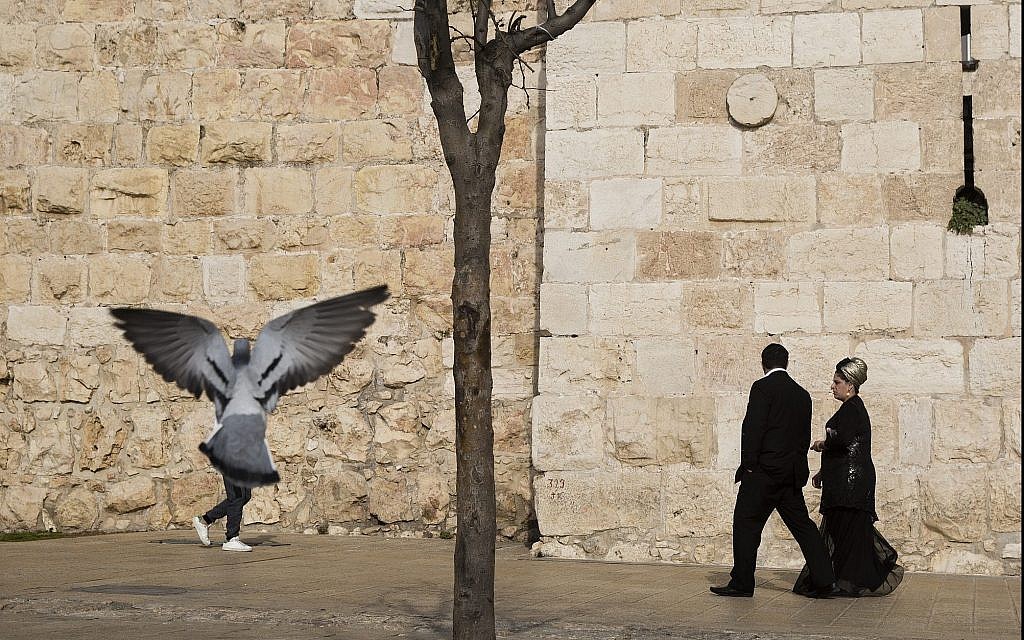 In this photo from December 23, 2017, people walk along the Old City of Jerusalem's walls, next to Jaffa Gate. (AP Photo/Oded Balilty)