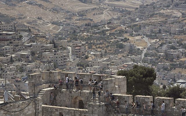 People tour the Jerusalem Ramparts Walk on Jerusalem's Old City walls overlooking the East Jerusalem neighborhood of Silwan,  May 24, 2017. (AP Photo/Oded Balilty)