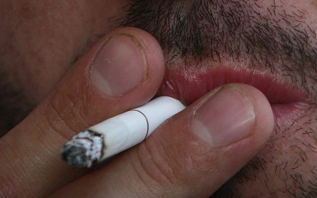 A man smokes a cigarette (Orel Cohen/ Flash90)