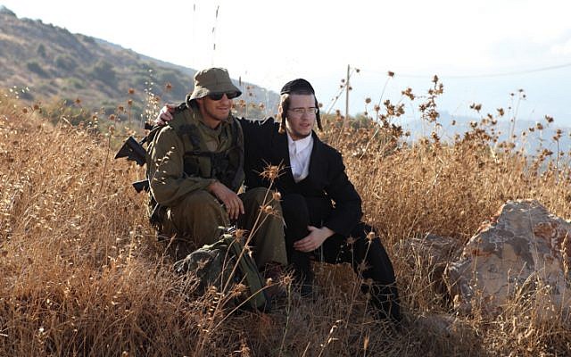 Illustrative: Soldiers of the IDF's ultra-Orthodox Netzah Yehuda Battalion sit in a field at the Peles Military Base, in the Northern Jordan Valley. (Yaakov Naumi/Flash90)