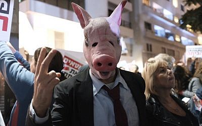 A protester wearing a pig mask attends a protest against government corruption in Tel Aviv on December 9, 2017.  (Tomer Neuberg/Flash90)
