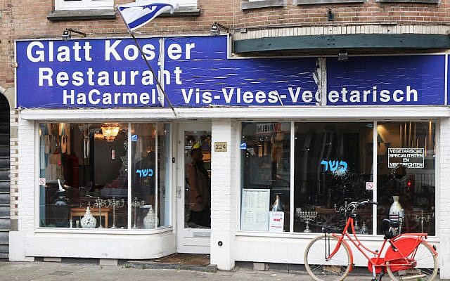 A man waving a Palestinian flag smashed the windows of the HaCarmel kosher restaurant in Amsterdam, December 7, 2017. (Ginopress B.V./AFP/Getty Images/via JTA)