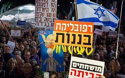 Israelis holding signs and shout slogans during a protest against the corruption of the government in Tel Aviv on December 16, 2017. (Miriam Alster/Flash90)