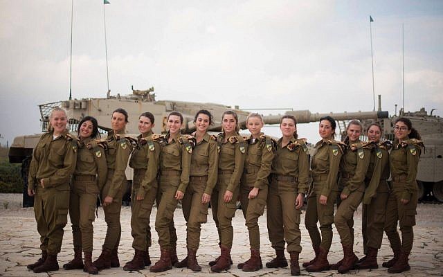 Israel's 13 first female tank operators, who completed their training on December 5, 2017, pose for a photograph at the Armored Corps' monument in Latrun, outside Jerusalem. (Israel Defense Forces)