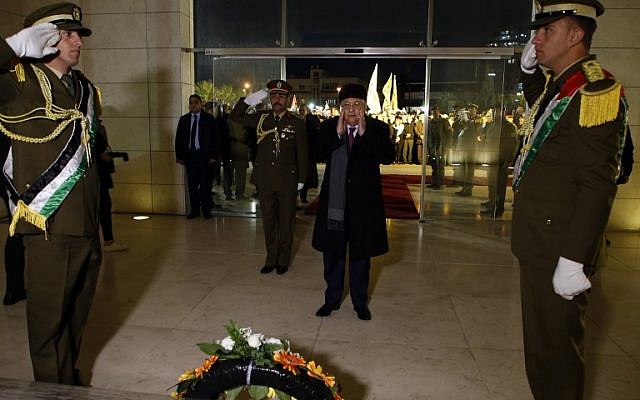 Palestinian Authority President Mahmoud Abbas (C) looks on after laying wreath of flowers on the tomb of the late PA President Yasser Arafat during a celebration marking the fifty-third anniversary of the creation of the Fatah movement in the West Bank city of Ramallah on December 31, 2017. (AFP PHOTO / ABBAS MOMANI)