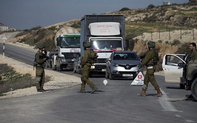 Illustrative: Israeli soldiers inspect cars at a checkpoint near the West Bank city of Nablus on January 10, 2018. (Jaafar/Ashtiyeh/AFP)