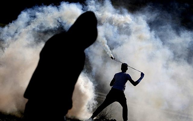 Palestinian protesters clash with Israeli security forces on January 13, 2018, in the West Bank village of Nabi Saleh. (AFP PHOTO / ABBAS MOMANI)