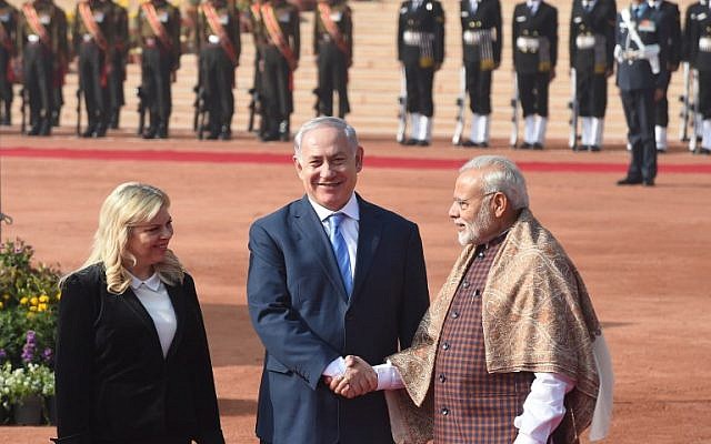Indian Prime Minister Narendra Modi (R) shakes hands with Israeli Prime Minister Benjamin Netanyahu (C) as his wife Sara Netanyahu looks on at the start of a ceremonial reception at the Presidential Palace in New Delhi on January 15, 2018. (AFP PHOTO / PRAKASH SINGH)