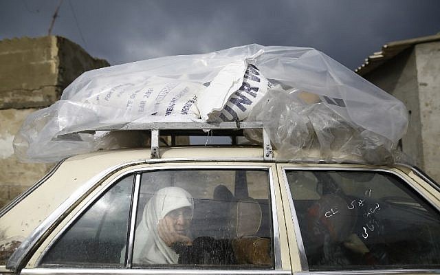 A Palestinian woman rides in a car after collecting aid provided by the UN agency for Palestinian refugees UNWRA, in Gaza City on January 17, 2018. (AFP/Mohammed Abed)