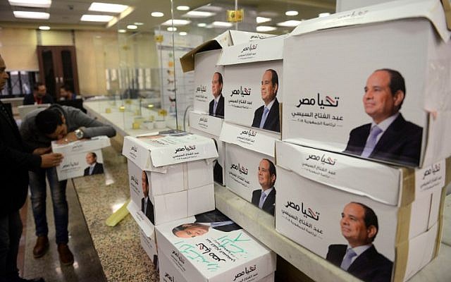 Members of Egyptian President Abdel Fattah el-Sissi's campaign staff stand next to boxes containing the signatures of support needed to register for the elections, at the National Election Authority in Cairo, on January 24, 2018. (AFP Photo/Mohamed El-Shahed)