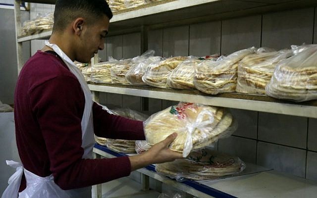 A Jordanian worker packages bread at a bakery in the Jordanian capital Amman on January 27, 2018. (AFP / Khalil MAZRAAWI)