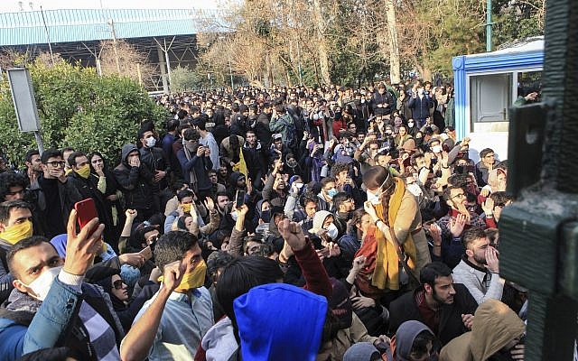 University students attend a protest inside Tehran University while a smoke grenade is thrown by anti-riot Iranian police, in Tehran, Iran, December 30, 2017. (AP Photo)