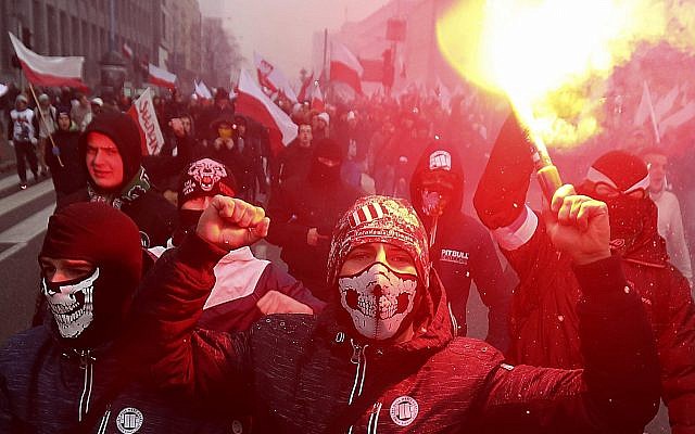 In this file photo from November 11, 2016, far-right nationalists burn flares as they march in large numbers through the streets of Warsaw to mark Poland's Independence Day. (AP Photo/Czarek Sokolowski, File)