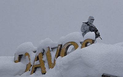 An armed Swiss police officer stands guard on the roof of a hotel near the congress center where the annual meeting of the World Economic Forum is taking place in Davos, January 22, 2018. (AP Photo/Markus Schreiber)