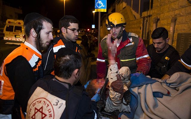 Rescue and medic personnel, including ultra-Orthodox paramedics, carrying a wounded woman at the scene of where the top floor of a building collapsed after a gas tank exploded in the Gilo neighborhood, Jerusalem, January 20, 2014. (Yonatan Sindel/Flash90)