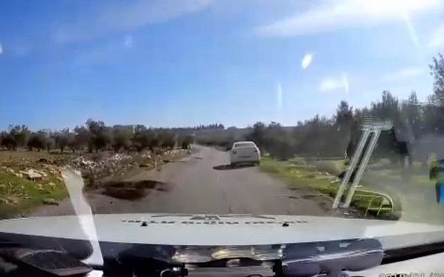 Still from video of police car rescuing tourist vehicle that strayed into West Bank Arab village of Teqoa on January 9, 2018. (Screen capture: Hadashot news)