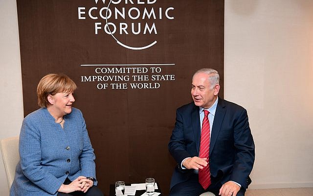 Prime Minister Benjamin Netanyahu meets with German Chancellor Angela Merkel, in Davos, Switzerland, on January 24, 2018. (Amos Ben Gershon/ GPO)