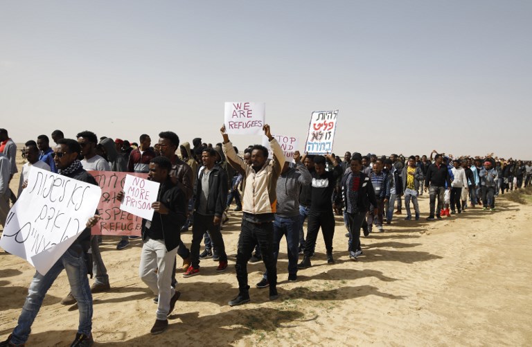 African migrants march from Holot detention centre to the Saharonim Prison, an Israeli detention facility for African asylum seekers on February 22, 2018. (AFP / MENAHEM KAHANA)