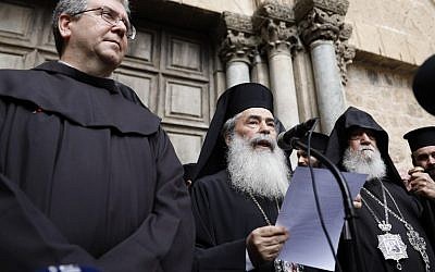 Greek Orthodox Patriarch of Jerusalem Theophilos III delivers a statement to the press as he stands next to the Custodian of the Holy Land Fr. Francesco Patton and Armenian Bishop Siwan (L) on February 25, 2018, outside of the closed doors of the Church of the Holy Sepulchre in Jerusalem's Old City. (AFP Photo/Gali Tibbon)